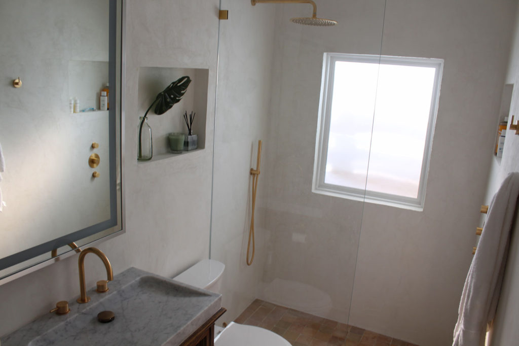 The same angle as the before photo with clean tadelkt walls and gold faucets