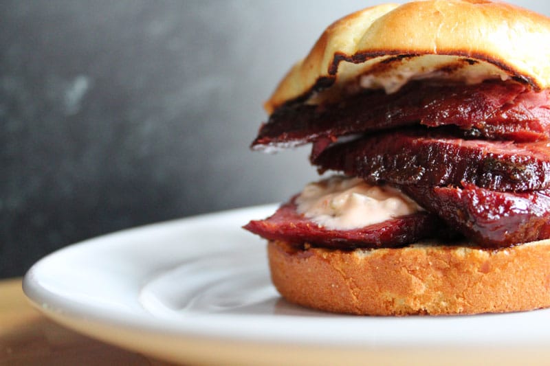 A close up of lots of layers of corned beef on a sandwich