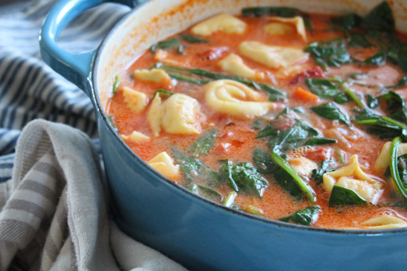 A pot full of sundried tomato tortellini soup